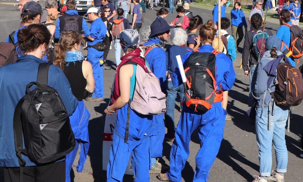 Groupe de manifestants-randonneurs en bleu de travail