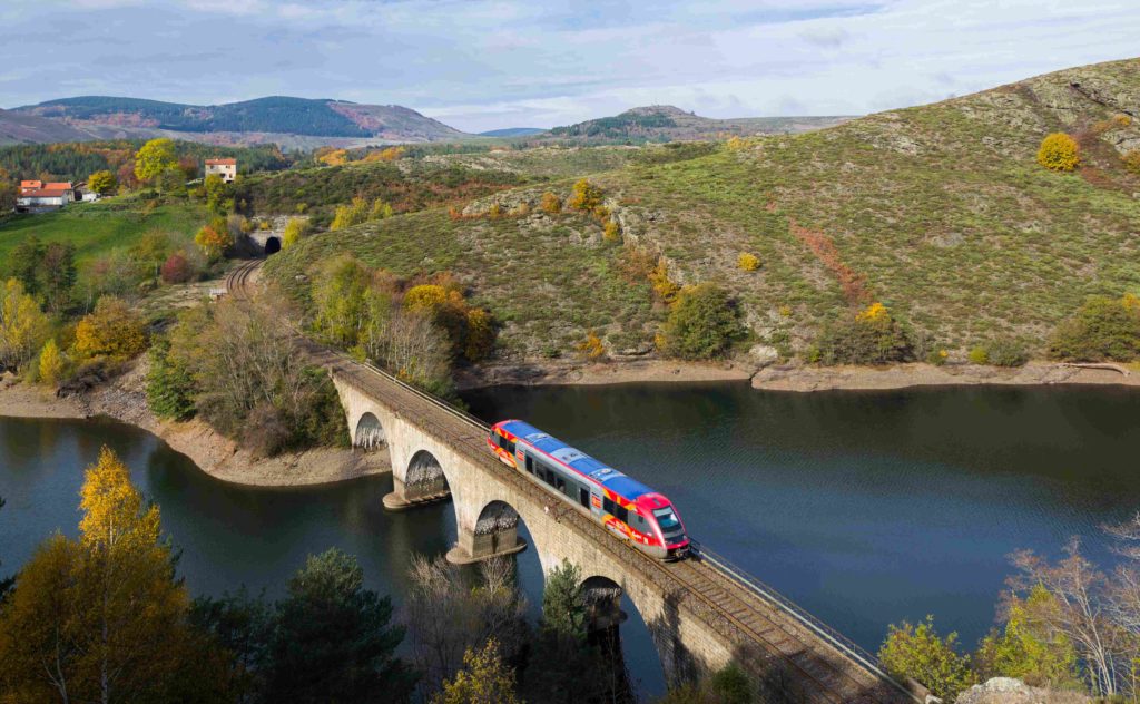 Vue aérienne du Cévenol aux couleurs de la région Occitanie, traversant un pont