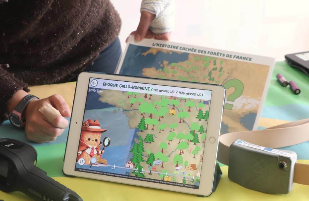 Tablette de réalité virtuelle placée devant la carte de France des forêts