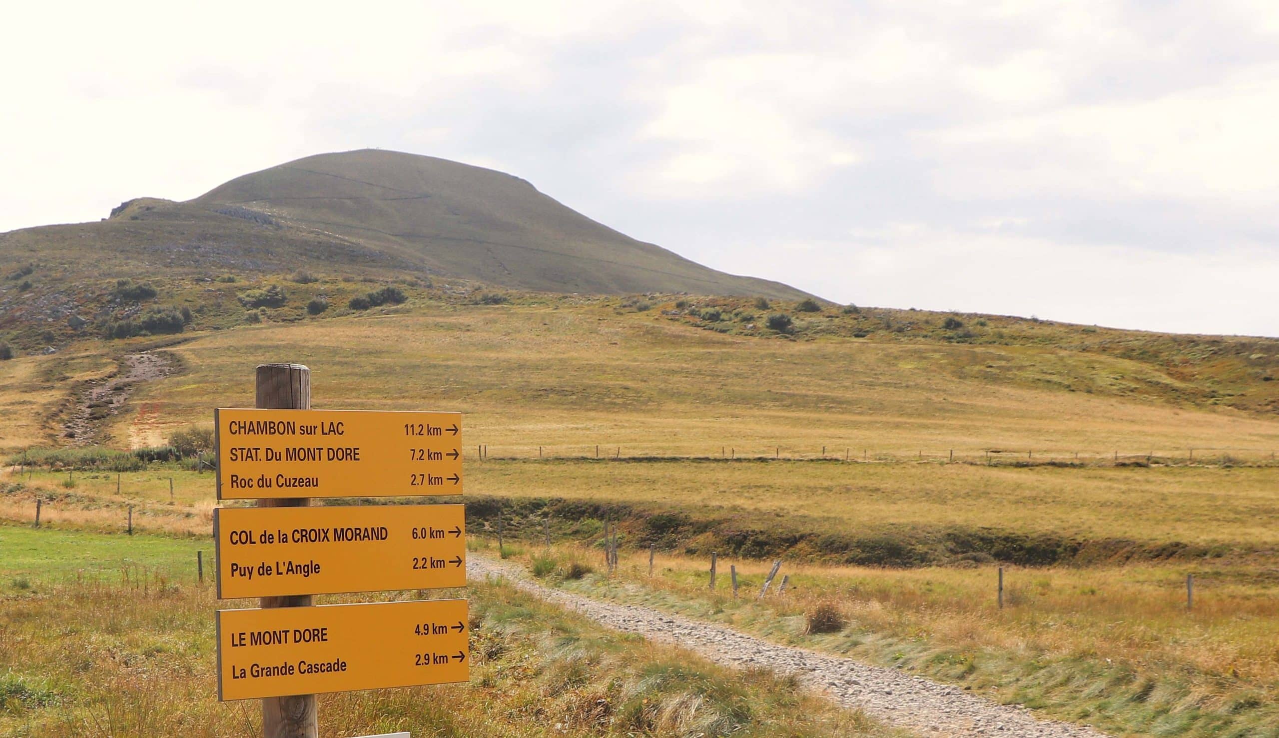 Paysage du Sancy avec au premier plan des panneaux indicateurs pour randonneurs