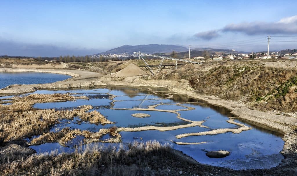 Vue aérienne de la zone à l'époque des carrières, avec le sol pelé autour des "trous" remplis d'eau