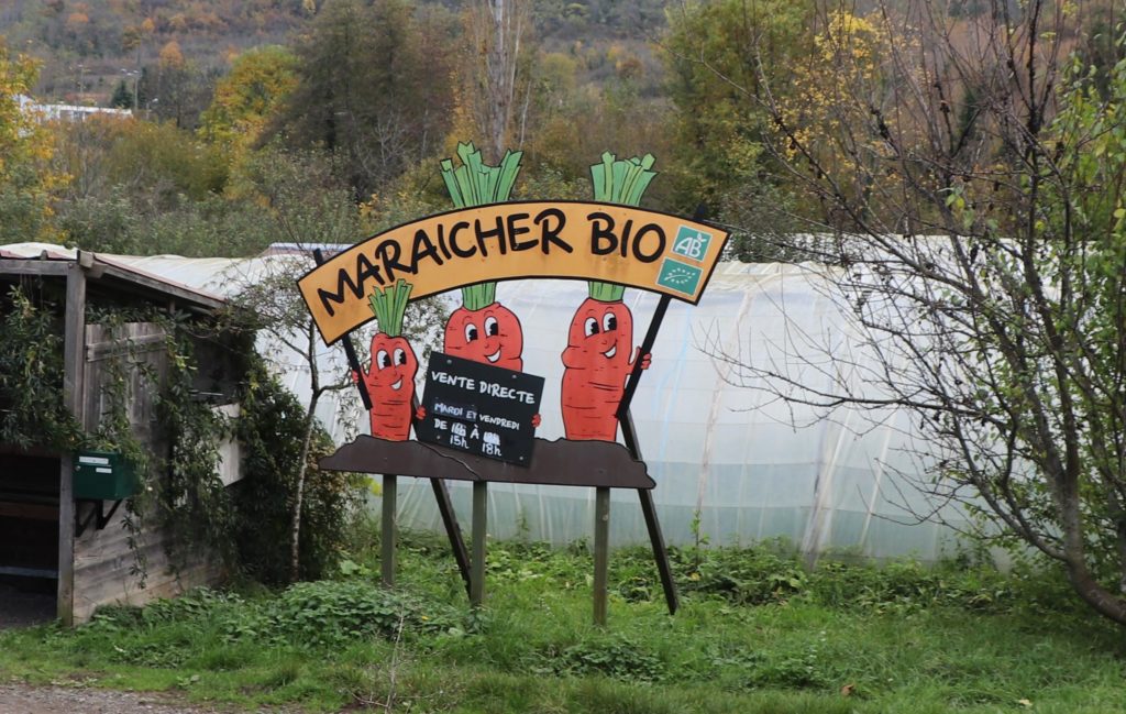 Grande pancarte du maraîcher bio avec des personnages en forme de carottes