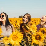 Jeunes femmes riant dans un champ de tournesols