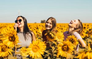 Jeunes femmes riant dans un champ de tournesols