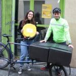 Agathe et Mika devant le local de Raboule, avec une boîte à pizza et le vélo-cargo